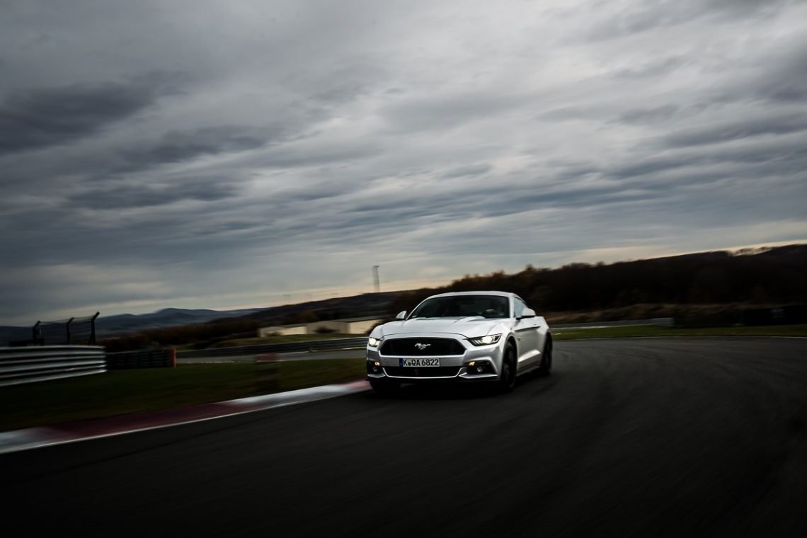 Ford Mustang GT 5.0 421 PS Bilster Berg Rennstrecke Racetrack Silber V8 Car2Car Driving Fahraufnahme Curb Rot Weiß Himmel Wolken Tagfahrlicht Racing