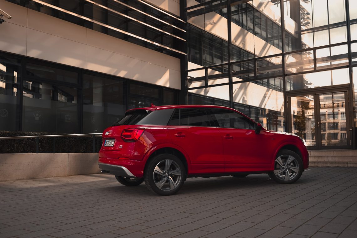 Audi Q2 Customizing Sport Sline rot Sonnenuntergang moderne Gebäudefront